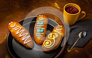 Three guaguas de pan on a plate next to a yellow jug with colada morada. Typical food of Ecuador on the day of the dead