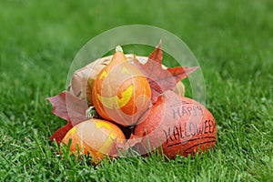 Three Halloween pumpkins on green grass