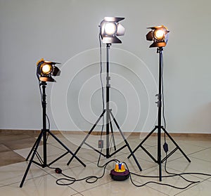 Three halogen spotlights with Fresnel lenses on a grey background. Photographing and filming in the interior