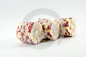Three halves of waxy corn isolated on white background