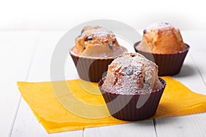 Three Handmade muffins on a wooden table