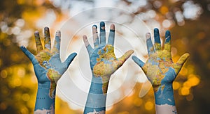 Three Hands Raised, World Map Painted, Autumn Background