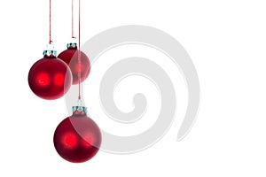 Three hanging Christmas balls at a white background