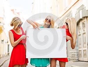 Three happy blonde women with blank white board