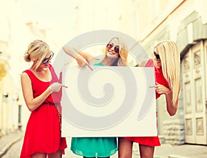 Three happy blonde women with blank white board