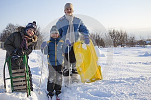 Three happy boys on sled and Skis in winter forest outdoors. Children active game