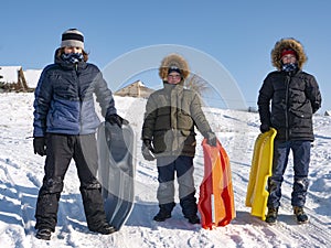 Three happy boys on sled and Skis in winter outdoors. Children active game