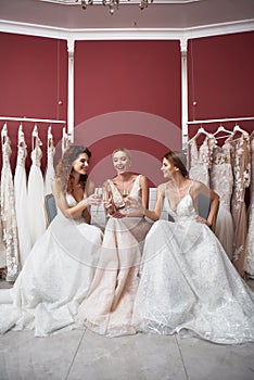 Three happy brides clanging glasses of champagne