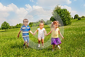 Three happy children holding hands and playing