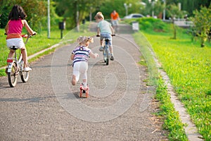 Three happy children riding on bicycle