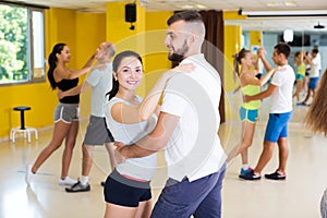 Three happy couples dancing tango