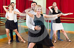 Three happy couples dancing tango