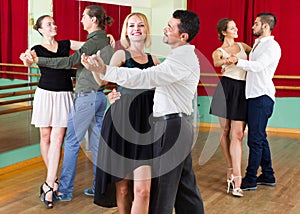Three happy couples dancing tango