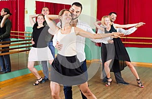 Three happy couples dancing tango