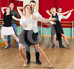 Three happy couples dancing tango