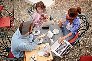 Three happy friends having coffee together