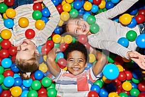 Three Happy Kids Playing in Ballpit