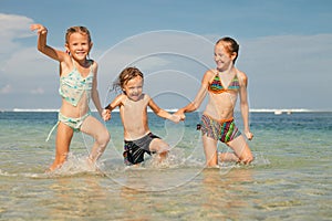 Three happy kids playing on beach