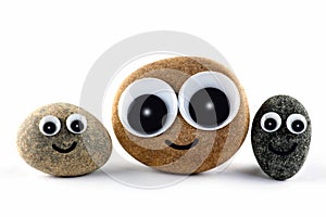 Three happy little faces on round pebbles.