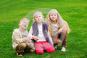 Three happy little kids chew gum