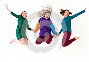 Three happy playful barefoot women of different age holding hands together