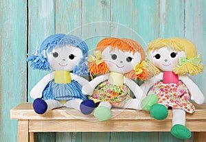 Three happy rag dolls on wooden background