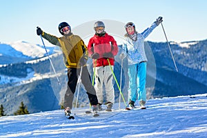 Three happy skiers having fun on winter ski slope