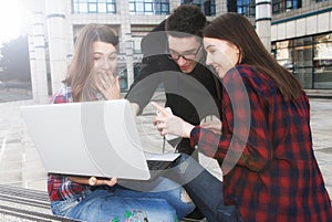 Three happy smiling high school teenager students with laptop a