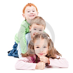 Three happy smiling kids lying on pile stack.