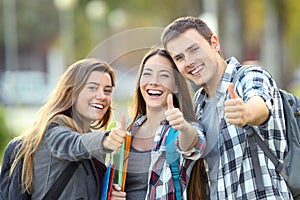 Three happy students with thumbs up