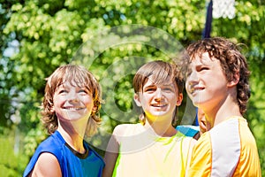 Three happy teenage boys smiling and looking up