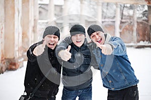 Three happy young men showing thumb up