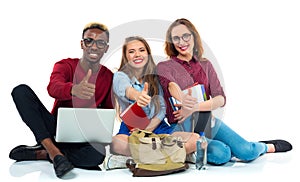 Three happy young teenager students with thumbs up isolated on w