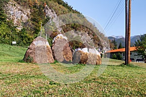 Three hay stacks on the field in mountains. Rural Landscape with haystacks