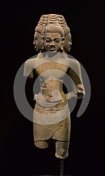 Three-headed Buddha stone statue black background