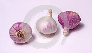 Three heads of garlic with pink, purple and white husks.