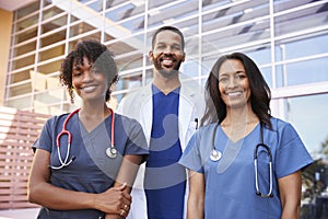 Three healthcare colleagues standing outside modern hospital