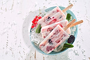 Three healthy berry and yogurt frozen iced lollies