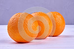 Three healthy oranges on wooden background.