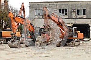 Three heavy excavators during a redevelopment work of urban area.