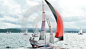 Three high school boys competing in a sailing regatta closeup at speed. Australia
