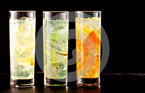 Three highball glasses filled with cocktail drinks