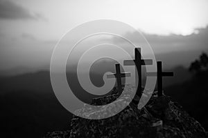 The three holy crosses of Jesus Christ shining through the red sky and clouds and bright rays background. Silhouette cross on