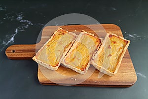Three of Homemade Pumpkin Tartlets on Wooden Breadboard