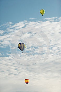 Three hot air balloons at a balloon rally.
