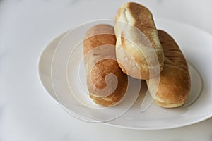 Three hot dog buns on a plate