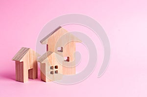 Three houses on a pink background. Buying and selling of real estate, construction. Apartments and apartments. City, settlement. M