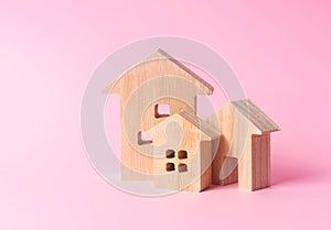 Three houses on a pink background. Buying and selling of real estate, construction. Apartments and residential buildings in a city