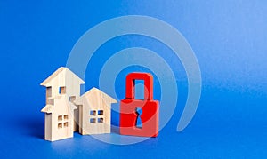 Three houses and a red padlock. Unavailable and expensive real estate. house Insurance. Security and safety. Confiscation