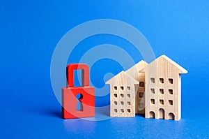 Three houses and a red padlock. Unavailable and expensive real estate. house Insurance. Security and safety. Confiscation